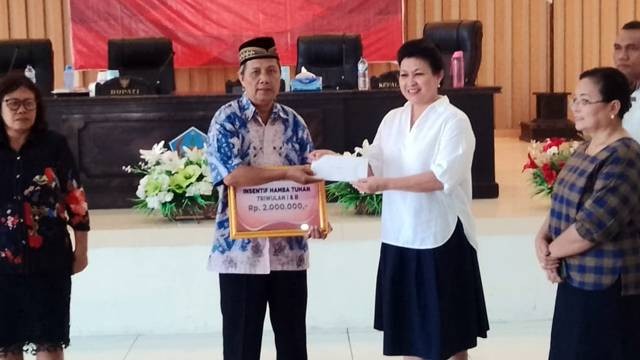 Bupati Kepulauan Sitaro, Evangelian Sasingen, saat menyerahkan bantuan kepada para tokoh agama.