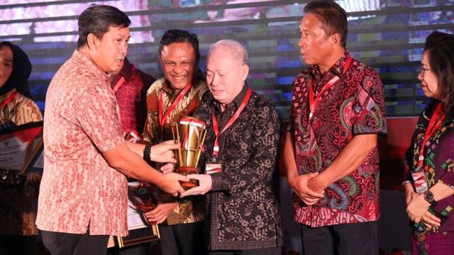 Wakil Gubernur Sulut, Steven OE Kandouw menyerahkan piala penghargaan ke Wakil Bupati Sitaro John Palandung, sebagai Kabupaten terbaik dalam penyelenggaraan Pemerintahan se Sulawesi Utara.