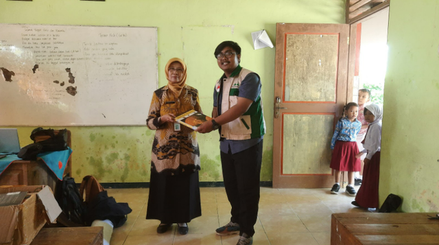 Penyerahan buku secara simbolis kepada kepala sekolah SD Negeri 2 Simo (foto dokumen pribadi TIM KKN-T Inovasi IPB 2023)