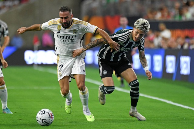 Pemain Real Madrid Dani Carvajal (kiri) berebut bola dengan pemain Manchester United Alejandro Garnacho selama pertandingan sepak bola persahabatan pramusim di Stadion NRG di Houston, Texas, pada Rabu (26/7/2023). Foto: Mark Felix/AFP