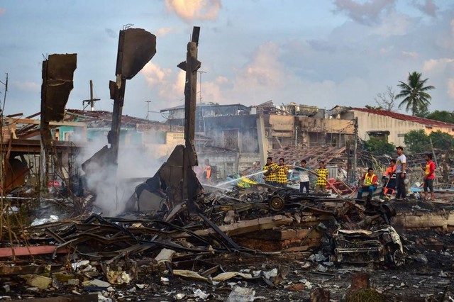 Petugas memeriksa lokasi kebakaran gudang petasan di Thailand. Foto: Madaree Tohlala/AFP