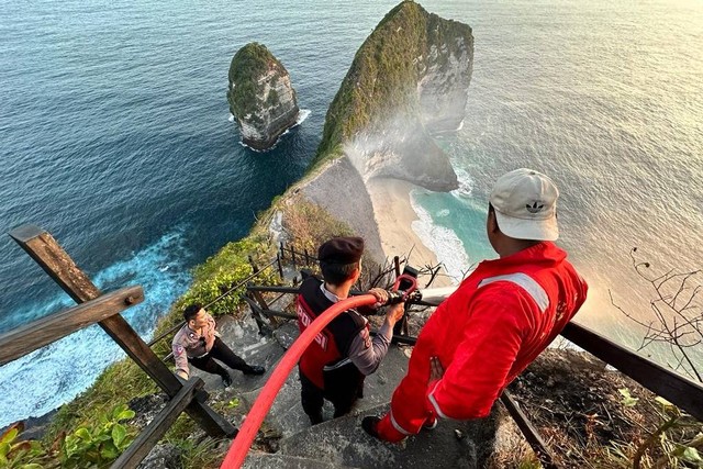 Polisi mengevakuasi wisatawan yang terjebak di Pantai Tebing Kelingking Beach, Bali, akibat kebakaran. Foto: Dok. Polsek Nusa Penida