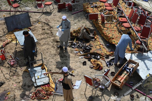 Petugas polisi memeriksa lokasi ledakan bom bunuh diri di distrik Bajaur, provinsi Khyber-Pakhtunkhwa, Pakistan, Senin (31/7/2023).  Foto: Abdul MAJEED / AFP