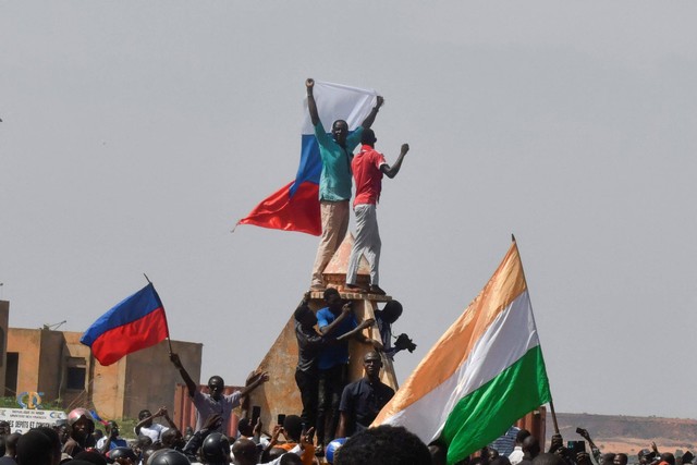 Para pengunjuk rasa mengibarkan bendera Niger dan Rusia saat mereka berkumpul selama rapat umum untuk mendukung junta Niger di Niamey pada 30 Juli 2023. Foto: AFP