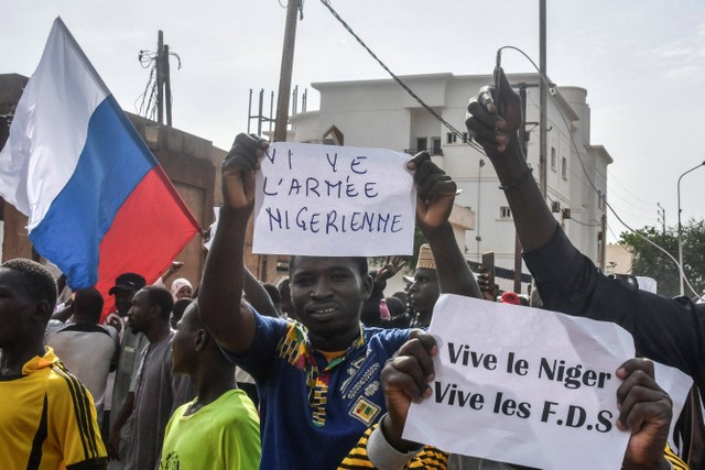 Para pengunjuk rasa mengibarkan bendera Niger dan Rusia saat mereka berkumpul selama rapat umum untuk mendukung junta Niger di Niamey pada 30 Juli 2023. Foto: AFP