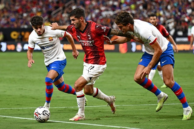 Gelandang Milan Christian Pulisic duel dengan gelandang Barcelona Abde Ezzalzouli dan bek Barcelona Marcos Alonso saat pertandingan persahabatan pramusim di Stadion Allegiant di Las Vegas, Nevada. Foto: Patrick T. Fallon / AFP