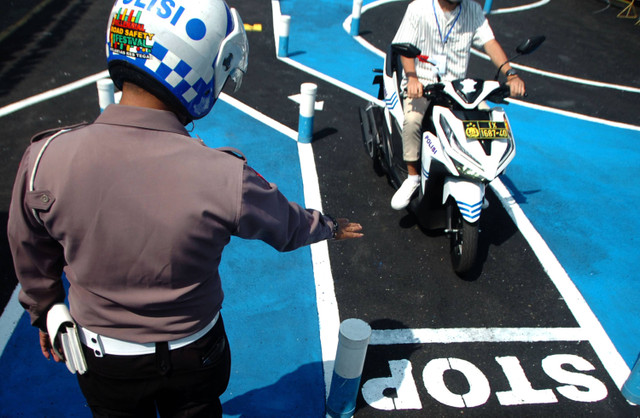 Personel Satlantas memberi arahan kepada peserta ujian praktek pembuatan Surat Izin Mengemudi (SIM) jalur baru berbentuk "S" di Polres Tegal, Jawa Tengah, Senin (7/8/2023). Foto: ANTARA FOTO/Oky Lukmansyah