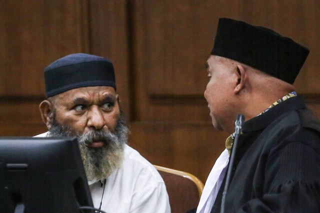 Terdakwa Gubernur nonaktif Papua Lukas Enembe (kiri) berbincang dengan kuasa hukumnya Petrus Bala Pattyona (kanan) saat menjalani sidang lanjutan di Pengadilan Tipikor, Jakarta, Senin (7/8/2023). Foto: Asprilla Dwi Adha/Antara Foto