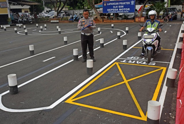 Anggota Polantas mengawasi warga yang menjalani ujian praktik SIM C di Satlantas Polres Kota Serang, Banten, Senin (7/8/2023). Foto: ANTARA FOTO/Asep Fathulrahman