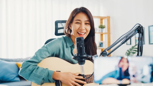 Gadis remaja memainkan musik untuk audiens online. Foto: Tirachard Kumtanom/Shutterstock.