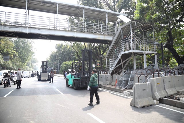 Petugas menggunakan forklift memasang pembatas beton untuk menutup jalan Medan Merdeka Barat jelang demo buruh di kawasan Patung Kuda, Jakarta Pusat, Kamis (10/8/2023). Foto: Fitra Andrianto/kumparan