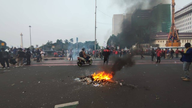 Massa buruh mulai bakar-bakaran di kawasan Patung Kuda, Jakarta, Kamis (10/8/2023).  Foto: Jonathan Devin/kumparan