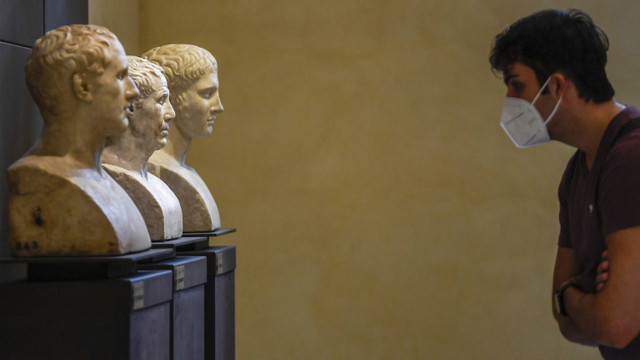 Seorang pengunjung yang mengenakan masker melihat patung marmer dari koleksi permanen di Museum Capitoline (Musei Capitolini) di Roma saat dibuka kembali pada 19 Mei 2020. Foto: Filippo Monteforte/AFP