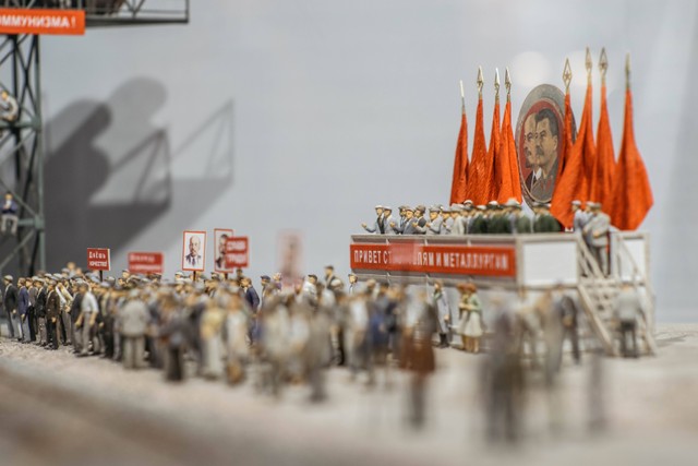 Ilustrasi miniatur rakyat tengah berdemo membelakangi mimbar besar dengan foto Lenin-Stalin. (foto: Unsplash.com)