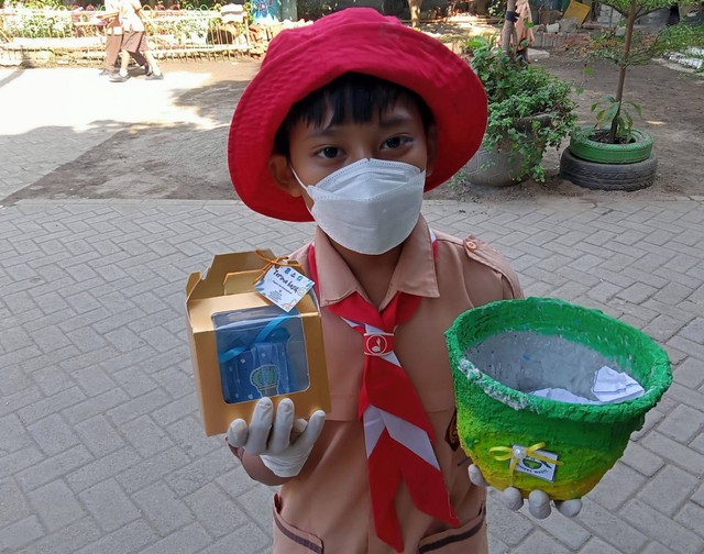 M.Bayu Panji Saputra, siswa kelas V SDN Nginden Jangkungan 1 Surabaya, menunjukkan pot tanaman dan suvenir yang dibuatnya dari limbah popok sekali pakai. Foto: Masruroh/Basra