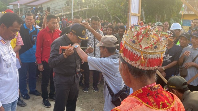 Ketua Komisi V DPR RI Lasarus disambut dengan prosesi adat saat tiba di Desa Landau Panjang untuk melakukan peletakan batu pertama pembangunan jembatan gantung. Foto: Yusrizal/Hi!Pontianak