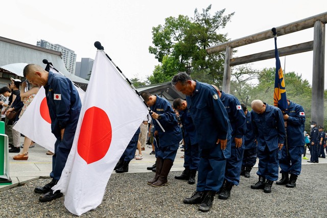 Aktivis sayap kanan memberikan penghormatan saat berkunjung ke Kuil Yasukuni pada peringatan 78 tahun penyerahan Jepang dalam Perang Dunia Kedua di Tokyo, Jepang, Selasa (15/8/2023). Foto: Kim Kyung-Hoon/REUTERS