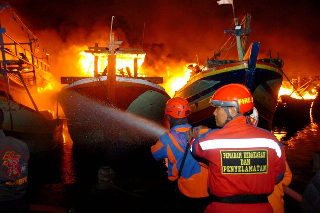 Petugas pemadam kebakaran berusaha memadamkan api yang membakar kapal nelayan, di Pelabuhan Jongor, Tegal, Jawa Tengah, Senin (14/8/2023) malam. Foto: Oky Lukmansyah/ANTARA FOTO