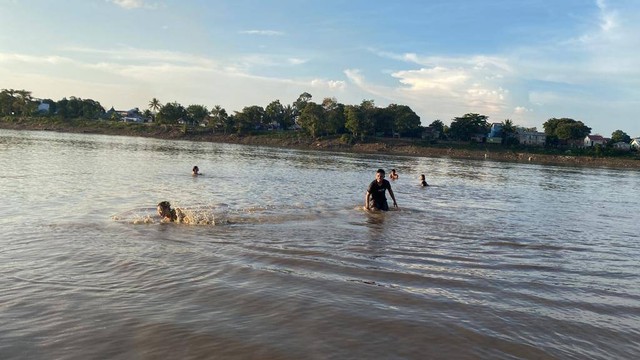 Warga mandi dan bersantai sore di pasir timbul Sungai Melawi, Kelurahan Sengkuang. Foto: Yusrizal/Hi!Pontianak