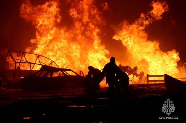 Petugas pemadam kebakaran bekerja di lokasi kecelakaan menyusul ledakan di sebuah pom bensin di kota Makhachkala, Rusia, Selasa (15/8/2023). Foto: Russian Emergencies Ministry/Handout via REUTERS