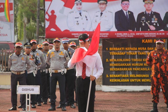 Robert Herison saat diminta mencium bendera merah putih. Dok: Ist.