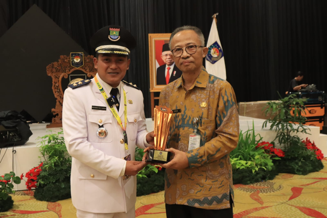 Lurah Cisauk, Kabupaten Tangerang, Banten, Moch. Farly Gusriadi (kiri) menerima piala juara terbaik 3 Regional II/Jawa-Bali pada Lomba Desa dan Kelurahan Tingkat Nasional 2023 di Hotel Discovery Ancol, Jakarta, Selasa (15/08/2023). Foto: Dok. Istimewa