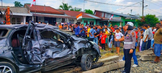 Polisi mengevakuasi kecelakaan mobil vs Kereta Api Sri Bilah di Kota Tebing Tinggi, Sumut, pada Rabu (16/8). Foto: Polres Tebing Tinggi
