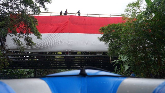 Bendera Merah Putih raksasa berukuran 23x9 meter membentang di atas Sungai Winongo, Yogya pada Kamis (17/8) pagi. Foto: Arif UT / Pandangan Jogja