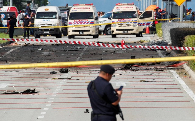 Pihak berwenang memeriksa lokasi kecelakaan pesawat di Shah Alam, Malaysia, Kamis (17/8/2023). Foto: Hasnoor Hussain/Reuters