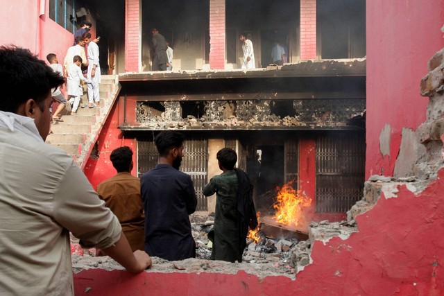 Orang-orang berkumpul di gedung gereja yang dirusak pengunjuk rasa di Jaranwala, Pakistan, Rabu (16/8/2023). Foto: Fayyaz Hussain/REUTERS