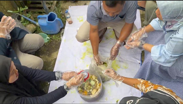 Mahasiswa KKN MMD UB bersama dengan perangkat desa Wonosalam mengolah limbah sampah menjadi Ecoenzym
