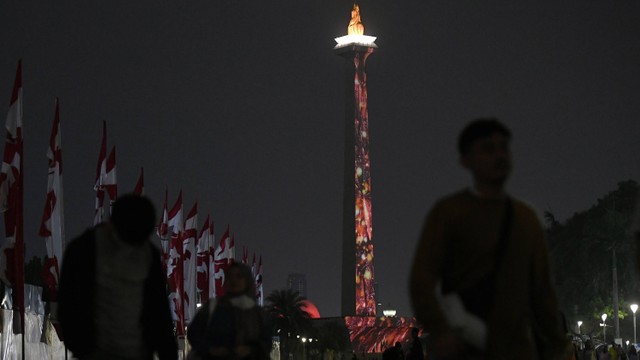 Pengunjung menyaksikan video mapping di Tugu Monas, Jakarta, Minggu (20/8/2023). Foto: ANTARA FOTO/Hafidz Mubarak A