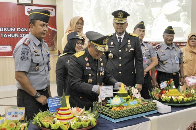 Ganda Samosir di dampingi Pimti dan Ka. UPT memotong Tumpeng Syukuran Hari Dharma Karya Dhika ke - 78. Dok. Wibi Humas Lapas Bengkulu