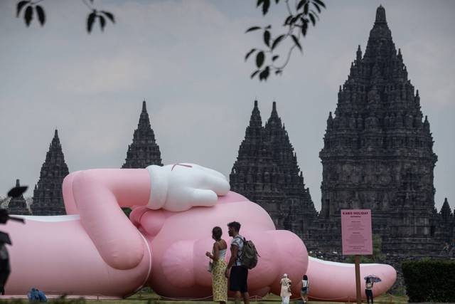 Pengunjung berada di dekat karya seni kontemporer seniman dunia Brian Donnelly atau KAWS saat pameran bertajuk Kaws : Holiday Indonesia di pelataran Candi Brahma di Kompleks Candi Prambanan, Sleman, D.I Yogyakarta, Sabtu (19/8/2023). Foto: Andreas Fitri Atmoko/ANTARA FOTO