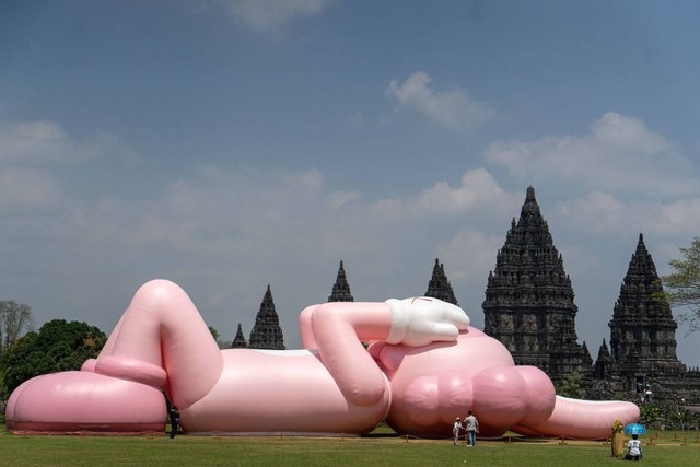 Pengunjung berada di dekat karya seni kontemporer seniman dunia Brian Donnelly atau KAWS saat pameran bertajuk Kaws : Holiday Indonesia di pelataran Candi Brahma di Kompleks Candi Prambanan, Sleman, D.I Yogyakarta, Sabtu (19/8/2023). Foto: Andreas Fitri Atmoko/ANTARA FOTO