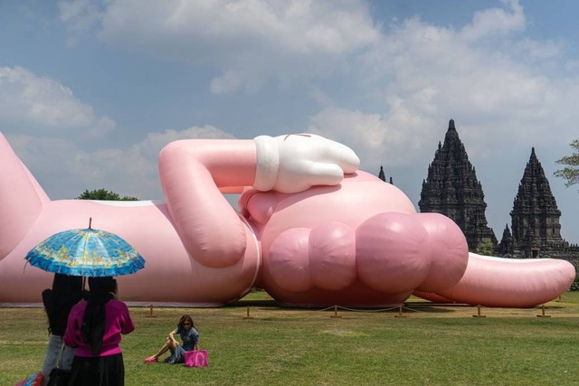 Pengunjung berada di dekat karya seni kontemporer seniman dunia Brian Donnelly atau KAWS saat pameran bertajuk Kaws : Holiday Indonesia di pelataran Candi Brahma di Kompleks Candi Prambanan, Sleman, D.I Yogyakarta, Sabtu (19/8/2023). Foto: Andreas Fitri Atmoko/ANTARA FOTO