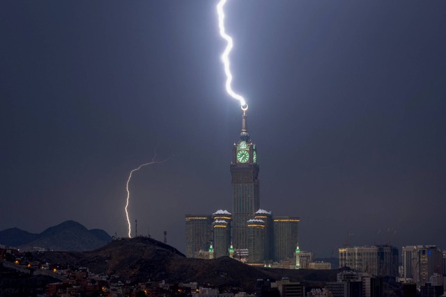 Kilatan petir di atas menara jam Makkah di Arab Saudi, Selasa (22/8/2023). Foto: HAMMAD AL-HUTHALI/AFP