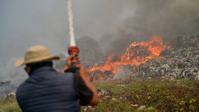 Petugas pemadam kebakaran berusaha memadamkan api yang membakar TPA Sarimukti di Kabupaten Bandung Barat, Jawa Barat, Rabu (23/8/2023). Foto: ANTARA FOTO/Raisan Al Farisi