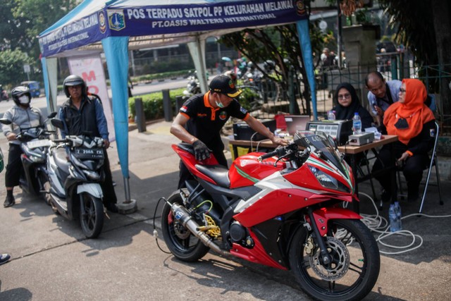 Petugas melakukan uji emisi di Terminal Blok M, Jakarta Selatan, Jumat (25/8/2023). Foto: Jamal Ramadhan/kumparan