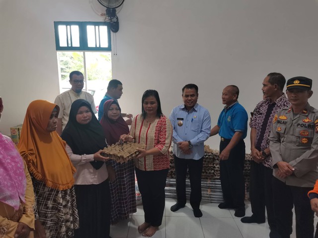 Bupati Aron bersama Ketua TP PKK Magdalena Susilawati Aron menyerahkan bantuan kepada korban insiden jembatan ambruk di Mentukak. Foto: Dok. Diskominfo Kabupaten Sekadau