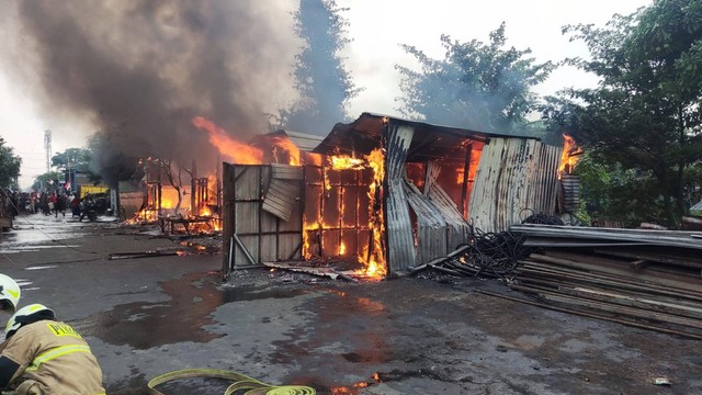 Petugas damkar memadamkan kebakaran rumah bedeng di Cakung, Jakarta Timur, Minggu (27/8).  Foto: Sudin Gulkarmat Jaktim