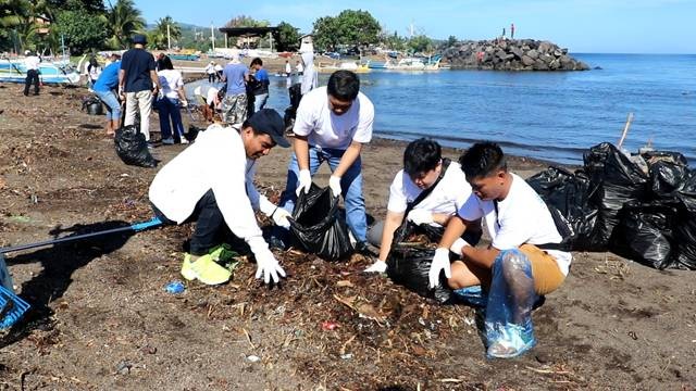 Milenial PLN UID Suluttenggo saat bersih-bersih pantai los Malalayang di Kota Manado dalam kegiatan BUMN Environmental Movement.