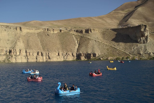 Orang-orang duduk di atas perahu dayung untuk berkendara di danau Band e-Amir di Provinsi Bamiyan, Afghanistan. Foto: Bulent Kilic/AFP
