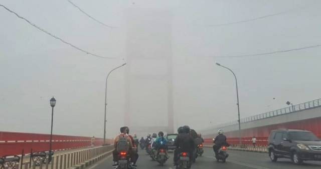 Suasana saat Jembatan Ampera Palembang yang tertutupi kabut asap di sore hari (13/10/2019). (foto: abp/Urban Id)