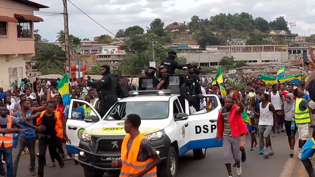 Pendukung kudeta menyemangati petugas polisi di Libreville, Gabon. Foto: GABON 24/via AP