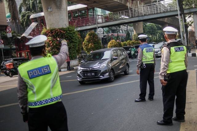 Polisi lalu lintas menghentikan kendaraan saat uji coba razia tilang uji emisi di Terminal Blok M, Jakarta Selatan, Jumat (25/8/2023). Foto: Jamal Ramadhan/kumparan