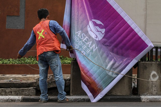 Petugas memasang banner KTT ASEAN di tiang monorel di Jalan Rasuna Said, Jakarta, Minggu (3/9/2023). Foto: Jamal Ramadhan/kumparan