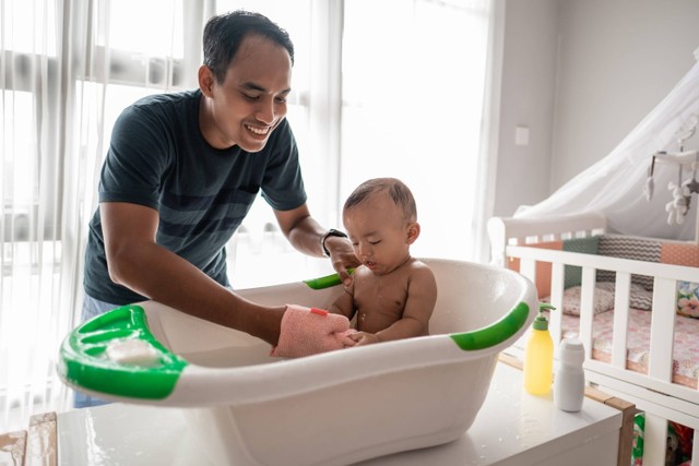 Ilustrasi ayah memandikan bayi. Foto: Shutterstock