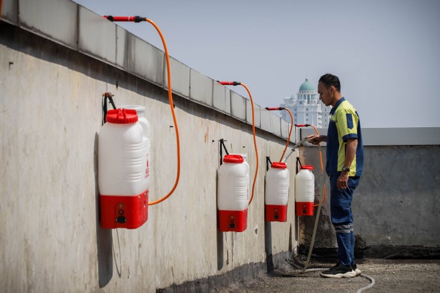 Petugas dari divisi Mekanikal Elektrikal Wali Kota Jakarta Pusat mengoperasikan water mist generator di rooftop Gedung Wali Kota Jakarta Pusat, Jakarta, Selasa (5/9/2023). Foto: Jamal Ramadhan/kumparan