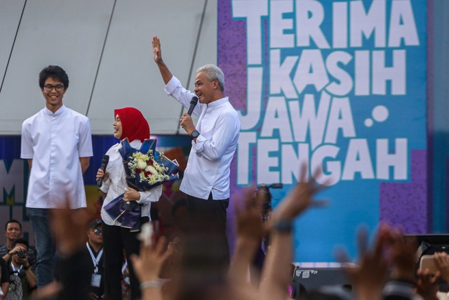 Ganjar Pranowo (kanan) didampingi istrinya Siti Atiqoh Supriyanti (tengah) dan putranya Zinedine Alam Ganjar (kiri) menyapa warga pada hari terakhir sebagai Gubernur Jateng. Foto: Aji Styawan/Antara Foto